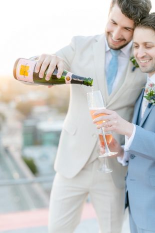 Photo of a same sex couple pouring champagne