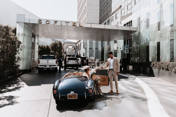 Photo of a couple getting out of a classic car in front of the hotel