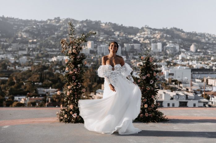 Photo of a bride posing on the helipad with city in the background