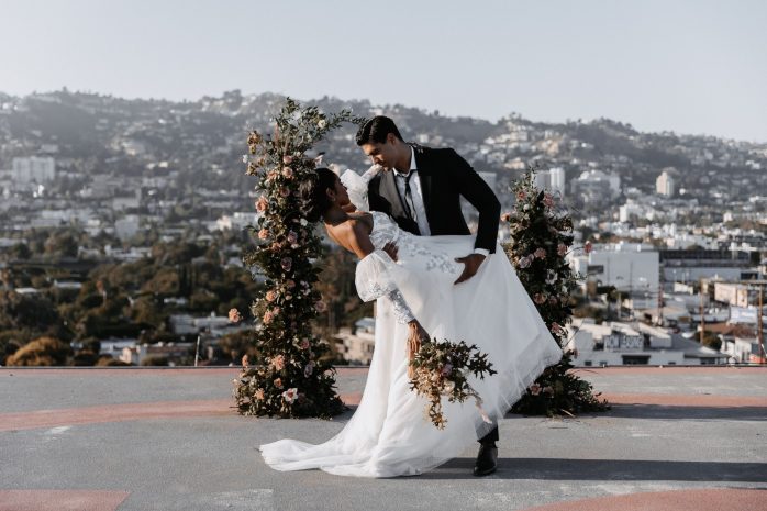 Photo of a bride and groom leaning back for a kiss on the helipad