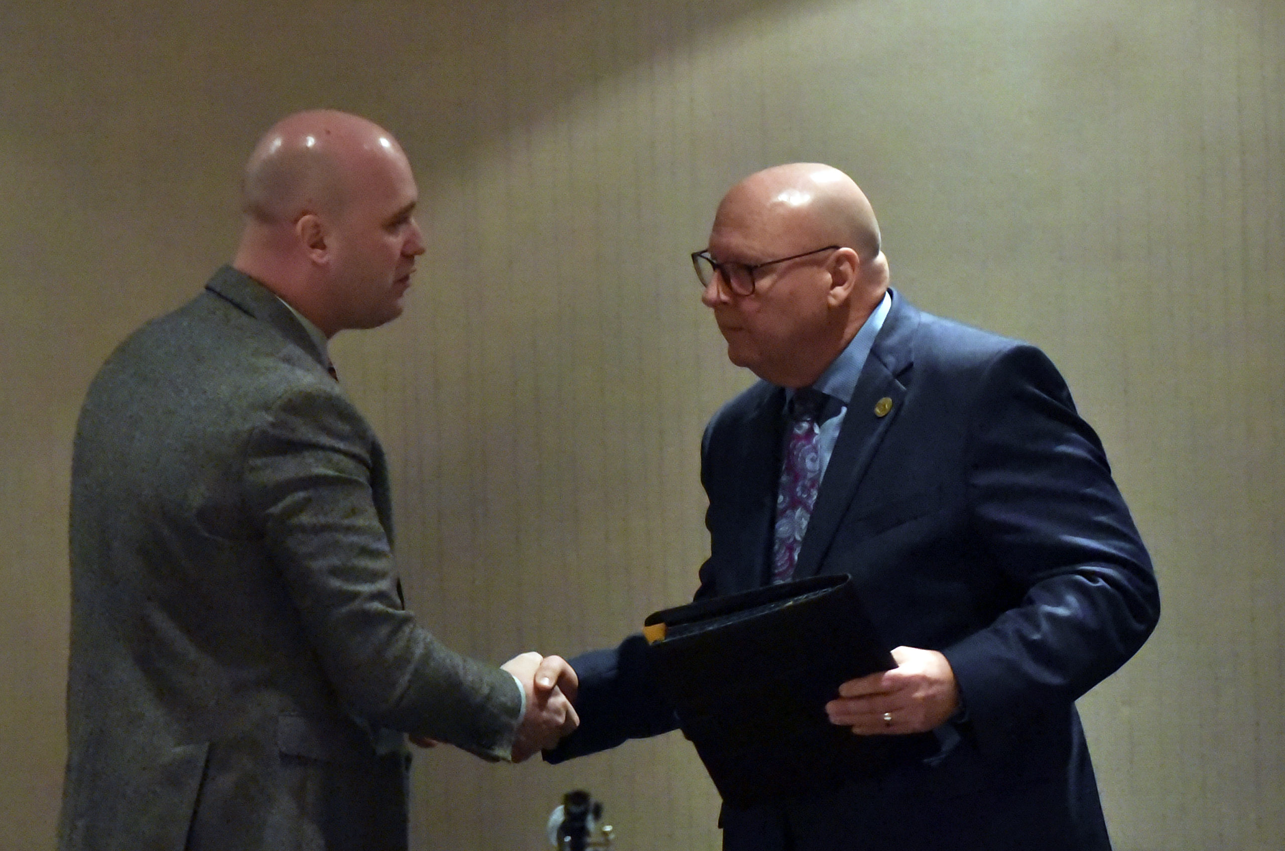 Commissioner Chairman Daniel Camp and Commissioner Jack Manning shake hands at the Annual State of the County meeting.