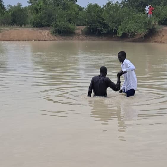 A person helping another person in the water