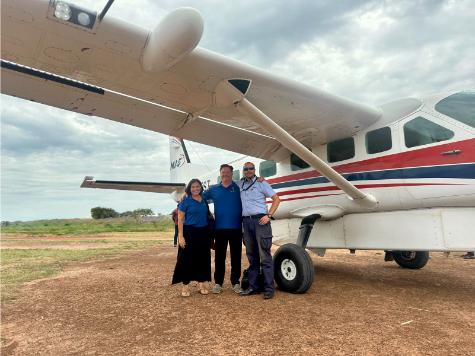 A group of people standing in front of a plane