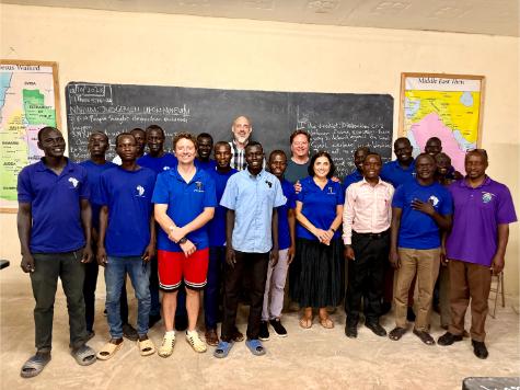 A group of people standing in front of a chalkboard