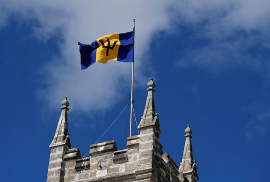 The flag of Barbados flutters on the Parliament buildings as preparations take place to mark the Caribbean island's transition to a republic, in Bridgetown, Barbados, November 29, 2021. REUTERS/Toby Melville/File Photo