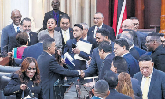 Finance Minister Dave Tancoo is congratulated by his colleagues after presenting his maiden Budget in Parliament yesterday. PHOTO BY ABRAHAM DIAZ