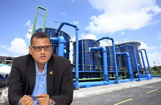 Minister of Housing and Water, Collin Croal and, in the background, the Wales Water Treatment Plant which was commissioned recently