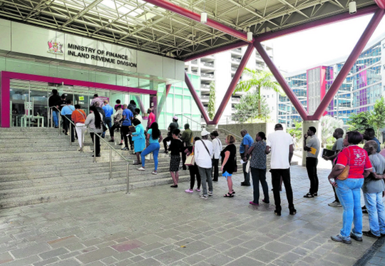 File: Members of the public wait in line outside the Ministry of Finance, Inland Revenue Division, Government Campus Plaza, Port-of- Spain in March. PHOTO BY ROGER JACOB
