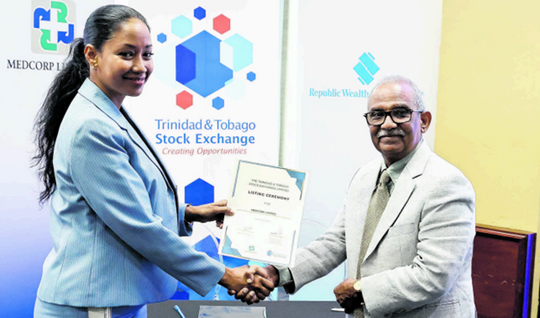 Trinidad and Tobago Stock Exchange CEO Eva Mitchell hands over the certification confirming Medcorp as an official listing to the TTSE to Dr Dinesh Mor, vice chairman of Medcorp yesterday. PHOTO BY ABRAHAM DIAZ