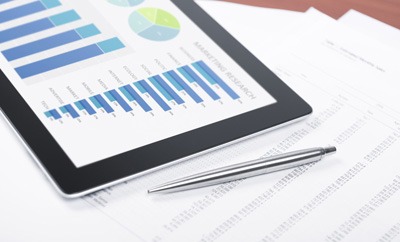 iPad with charts on screen and a ballpoint pen on documents