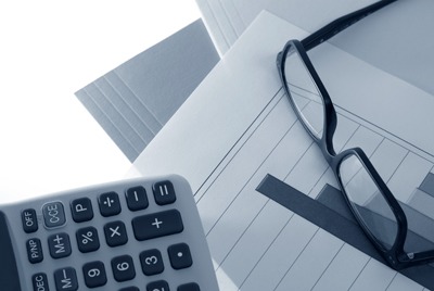Close-up of glasses and calculator on paper