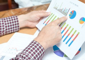 person looking at printed charts and graphs