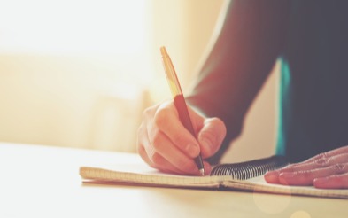 Female hands with pen writing in a notebook
