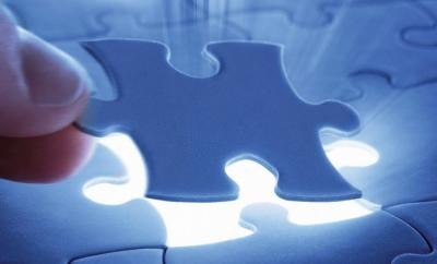 Fingers holding puzzle piece