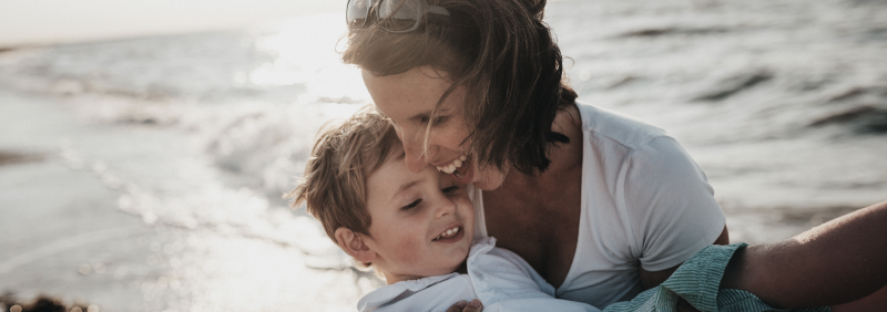 Woman holding child on beach