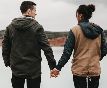 Couple looking out at beach, grateful for their comprehensive financial planning