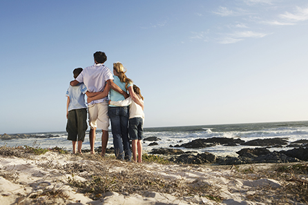 family of four looking out at the ocean on a sunny day