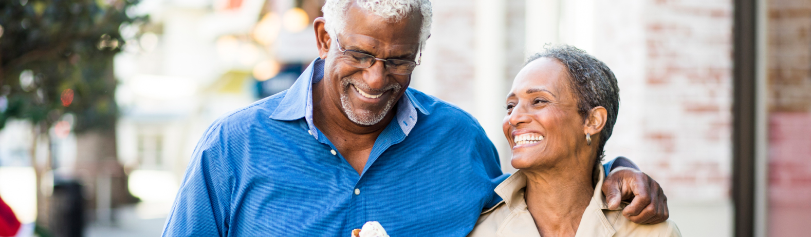 couple smiling and laughing together walking down a street