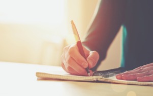Female hands with pen writing in a notebook