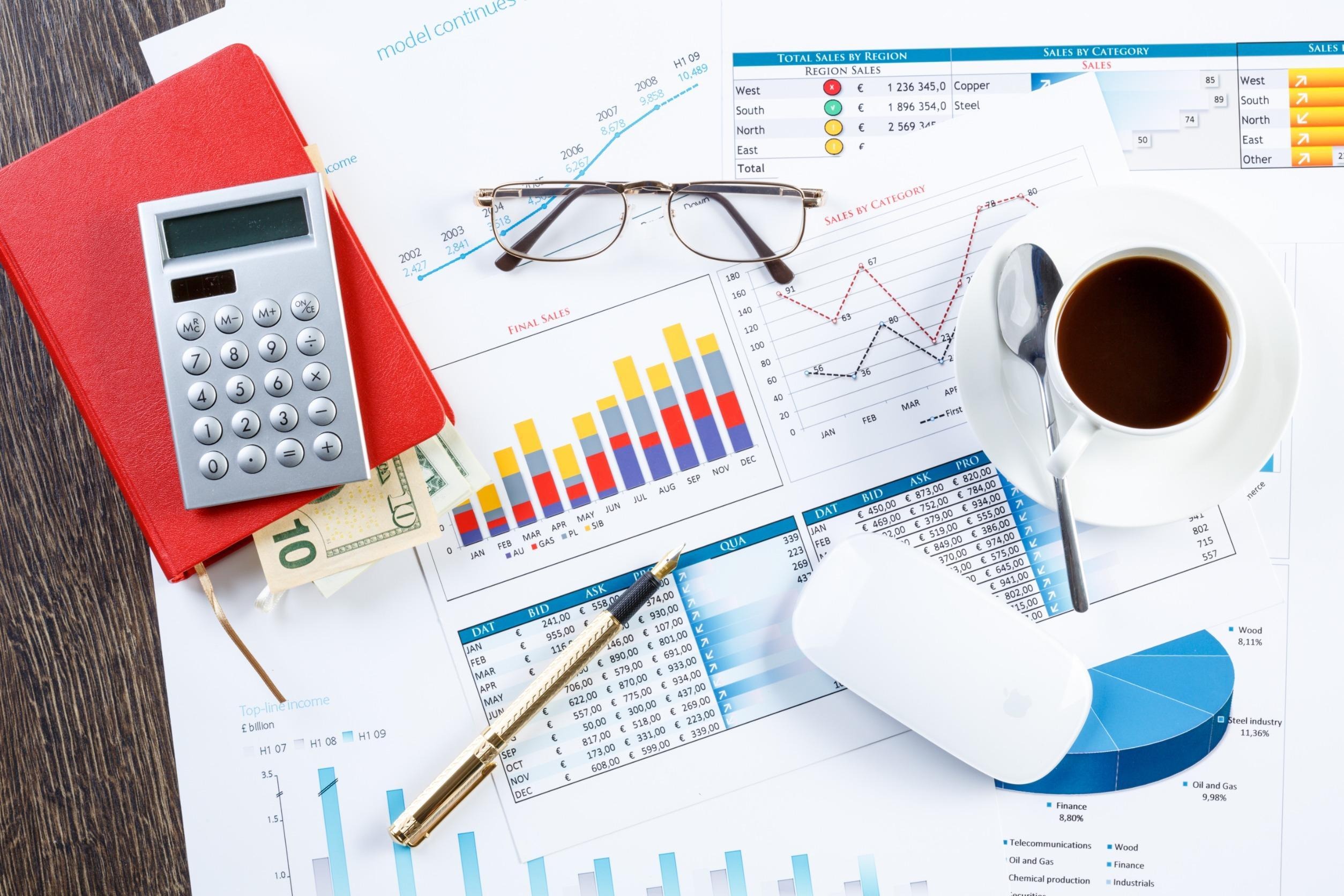 calculator, eyeglasses, cup of coffee, graphs and charts