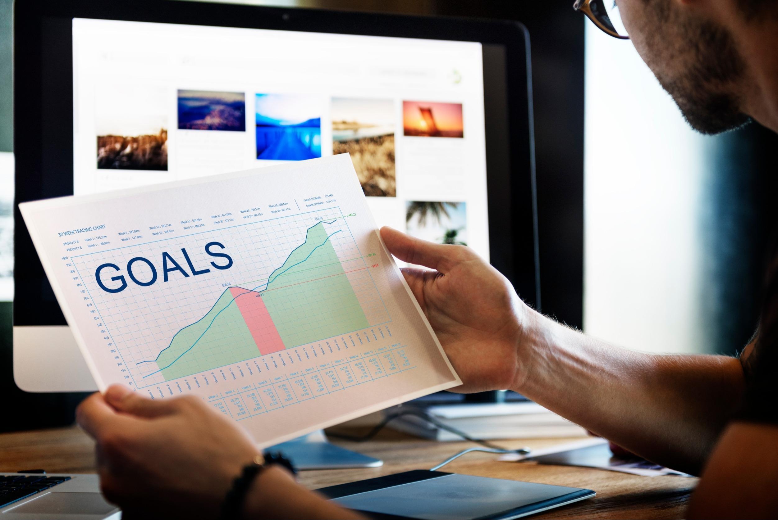 man looking at a goals chart