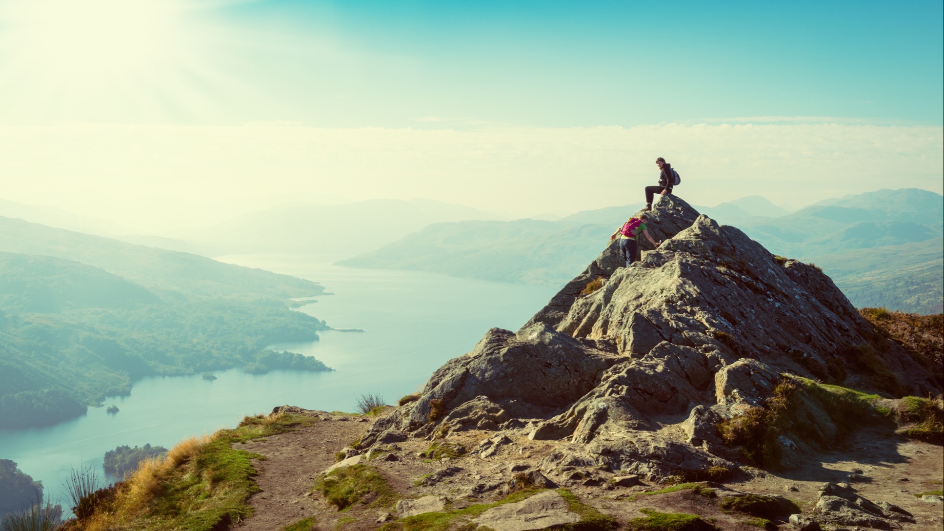 Two hikers on top of a mountain enjoying the view