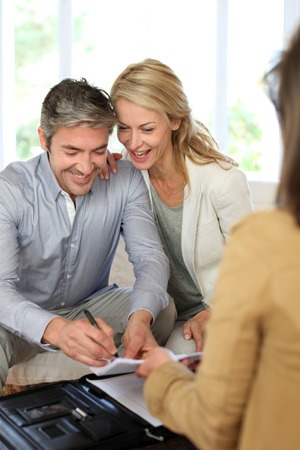 Clients smiling while signing a paper