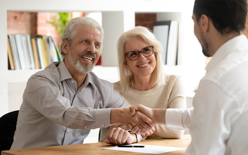 Older Couple shaking hands with advisor