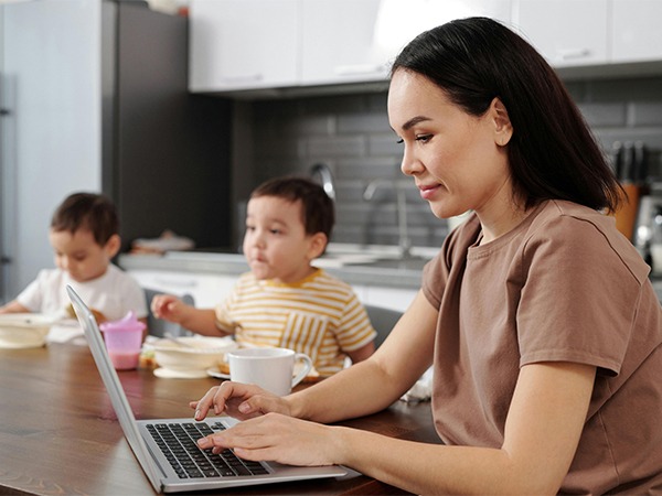 mother-working-on-laptop-with-children-at-table