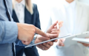 Business people discussing data displayed on a tablet