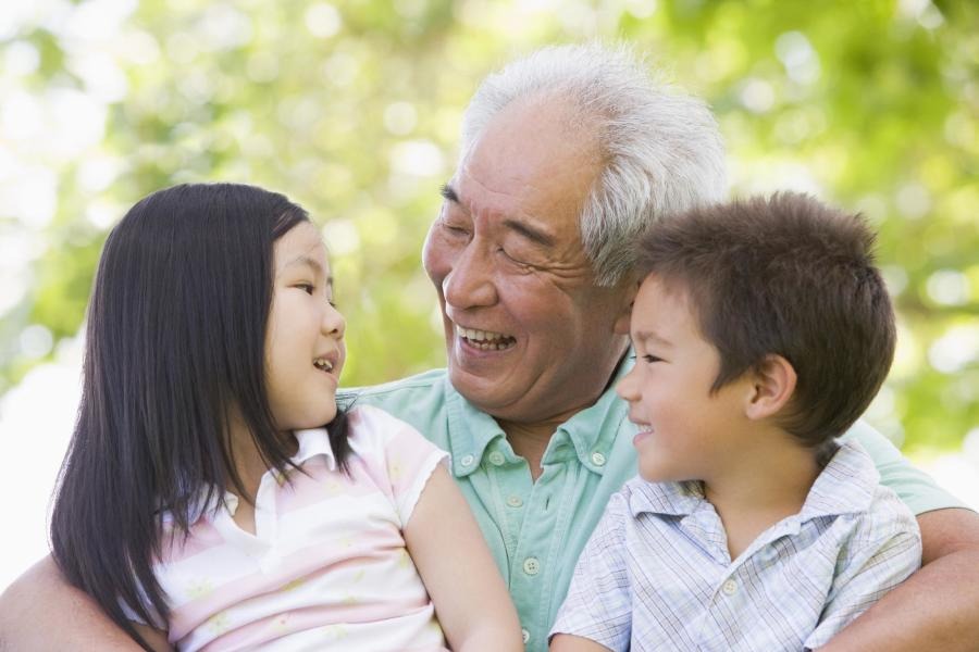 Grandfather laughing and visiting with grandchildren