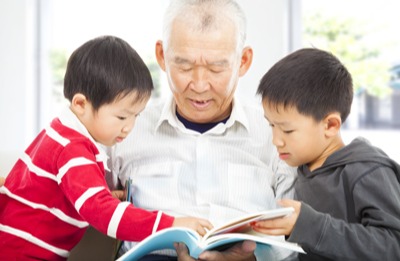 Grandfather reading with two grandsons