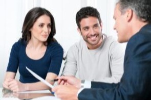 alt="Financial consultant reviews investments with a couple"