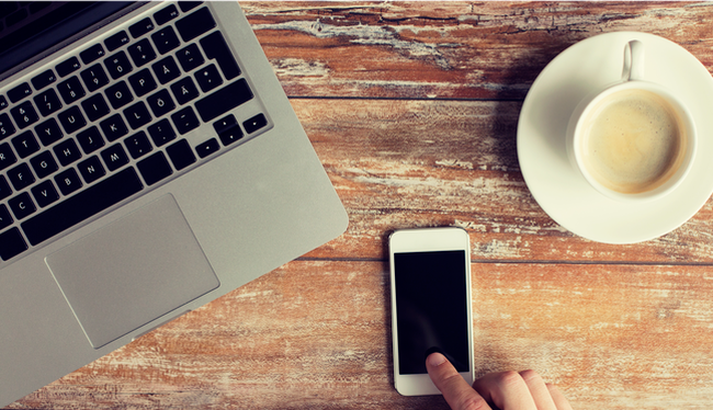 Computer, phone, and coffee on a desk