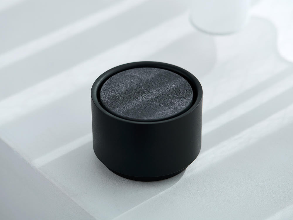 「Black」のアロマディフューザー本体には、粒子の異なる砂を配合して独特のクラフトな質感を表現した味わい深い「ASH GRAY」のアロマプレートがセットに。|香炉やオブジェのような洗練されたデザイン。水なし・コードレスで使えるアロマディフューザー|WEEK END(ウィークエンド)