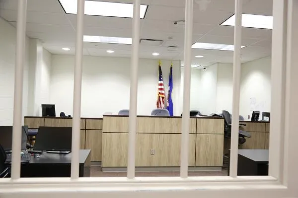 An arraignment court from inside inmate booth barred windows courtesy of Scott County Sheriff's Office, Minnesota
