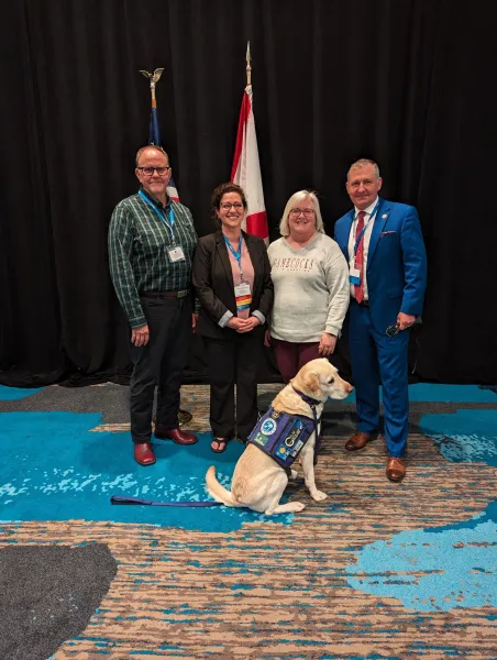 a photo of Scott Richards, 3 other speakers, and a service dog at a facilitated dialogue session at N.A.V.A.C. conference 2024