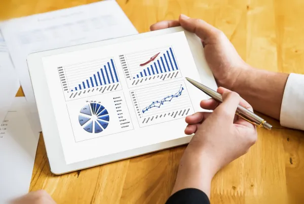 people looking at data charts and statistics on a tablet device