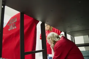 three women talking at their bunk bed in a prison cell