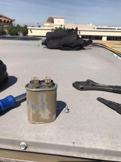 A cell phone provider in Porterville California requested urgent service for an AC issue, store was at 82 degrees. Upon arrival, our technician found a bad run capacitor and condenser fan motor with worn bearings. Replaced the capacitor to get the unit running, will need to replace the fan motor. Also found the blower motor missing a support bracket, causing excess vibration and belt wear. Unable to locate missing nut inside unit, will source for repairs and bring a new belt. Air filters are badly plugged and coils are very dirty. Stage-2 possibly low on charge, and minor leaks found on the discharge service ports. Will quote all necessary repairs and return, unit running for now.