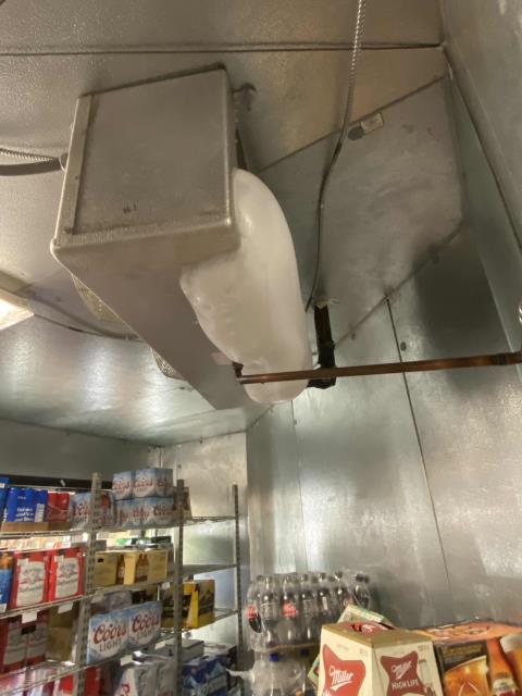 Follow-up visit to a pharmacy in Kern County, California, to troubleshoot icing found on their freezer evaporator section. Drain line was plugged, causing water to back up and evap to freeze. Cleared clog and cleaned pan, confirmed system back online.