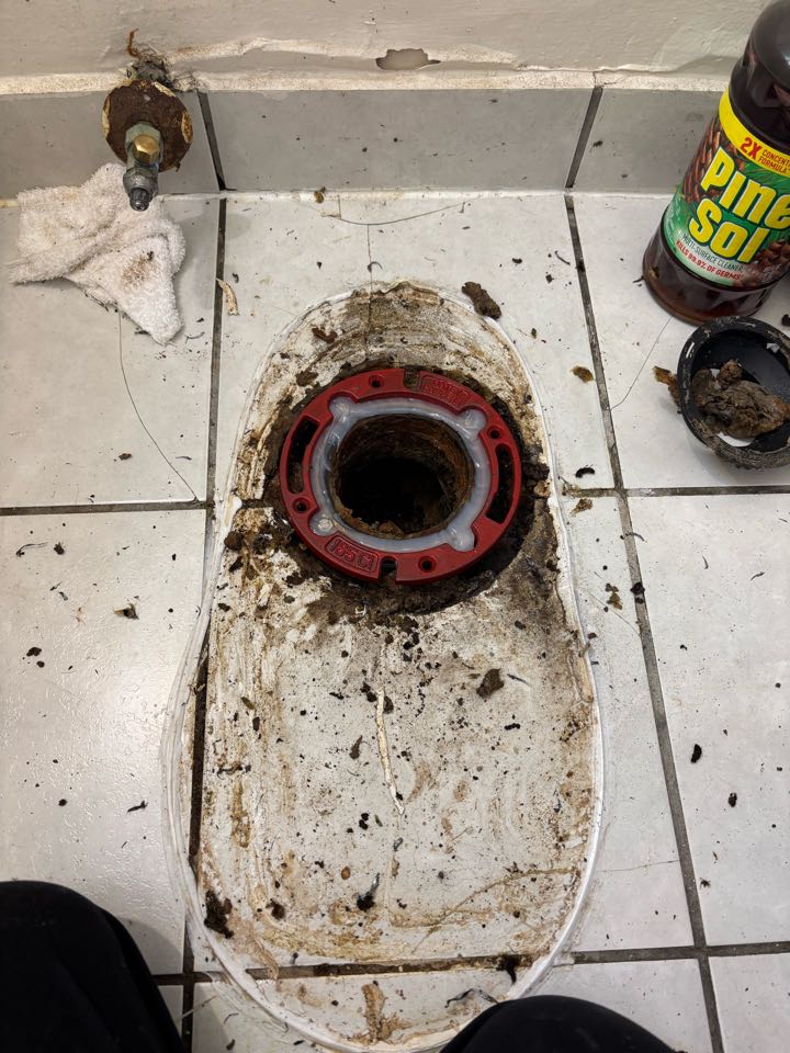 Repair a broken toilet flange that was causing it to leak between floors. 