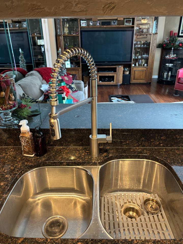 Install a new high arc pull-down Moen faucet to update the kitchen sink with a new style fixture.