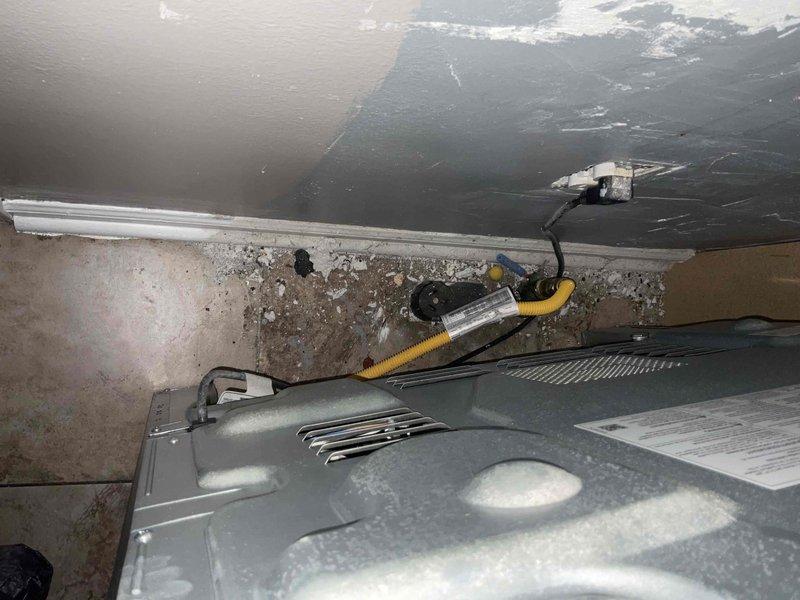 Conducted assessment for new whole home generator installation. Inspected existing electrical panel and meter connections at exterior wall, noting deteriorated brick surfaces around utility access. Evaluated interior utility space with visible water damage near ceiling junction and examined existing electrical components, including junction boxes and conduits, for potential integration with new generator system.