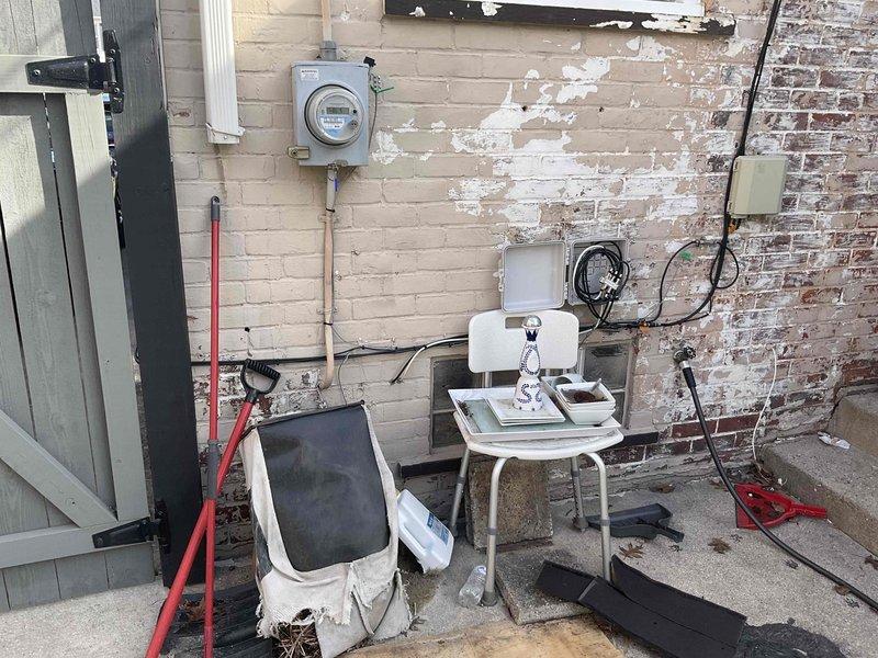 Conducted assessment for new whole home generator installation. Inspected existing electrical panel and meter connections at exterior wall, noting deteriorated brick surfaces around utility access. Evaluated interior utility space with visible water damage near ceiling junction and examined existing electrical components, including junction boxes and conduits, for potential integration with new generator system.