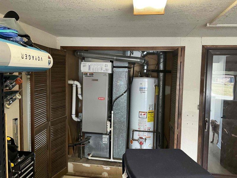 Conducted comprehensive inspection of 15+ year old furnace, A/C system, and water heater located in garage area. Equipment is currently operational but customer requested estimate for full replacement including zoning solutions for first and second floors. Documentation of existing GE SmartWater heater and connected HVAC components completed via photographic assessment to develop appropriate replacement proposal.