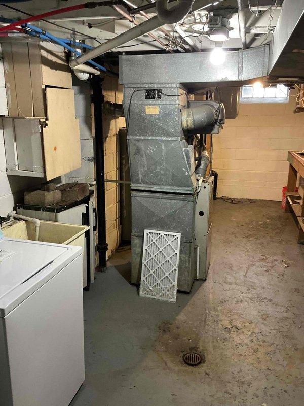 Conducted a comprehensive assessment of an aging forced air HVAC system located in a basement utility room. Evaluated the existing furnace unit with connected ductwork and documented the current installation conditions including adjacent water heater and available utility connections. Provided replacement options in accordance with the customer's interest in the BOGO promotion, with recommendation for prompt system replacement.