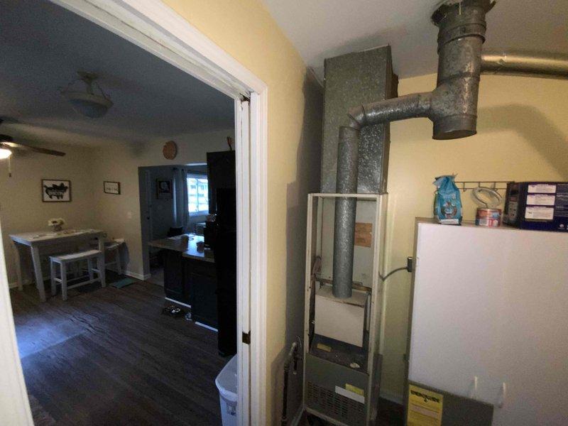 Performed comprehensive assessment for full HVAC system replacement in 1100 square foot residence with 16-year-old furnace. Inspected current installation configuration in utility area, evaluated existing ductwork connections, and documented electrical service capacity via exterior meter. Customer requires immediate replacement of both furnace and air conditioning components.