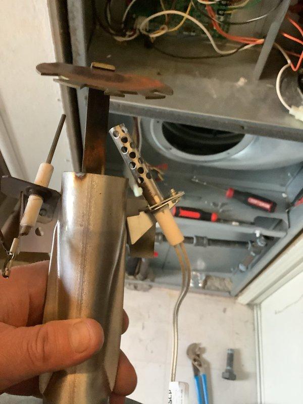 Performed diagnostic inspection of furnace system per previous assessment. Examined burner assembly/igniter component showing signs of heat exposure and wear. Verified Sensi thermostat operation (displaying 69°F, 37% humidity) with heating function active.