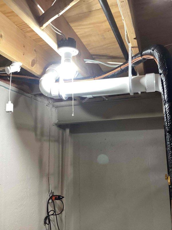 Completed installation of a complete HVAC system including a 135,000 BTU furnace, 5-ton Lennox air conditioning unit, and new hot water heater. System includes properly installed condensate drainage with PVC piping and P-trap configuration, with the outdoor AC unit mounted on a concrete pad with appropriate electrical connections.